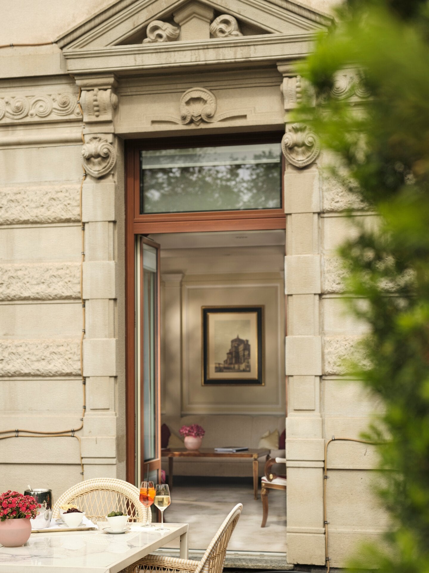 Vista della Principe Suite dalla Terrazza, in primo piano il tavolo in marmo con un aperitivo, sullo sfondo dettagli di design della suite