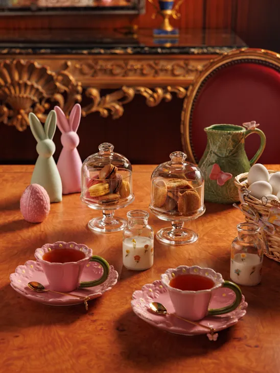 Wonderland-themed tea party table decor featuring colorful teacups, teapots, and pastries.