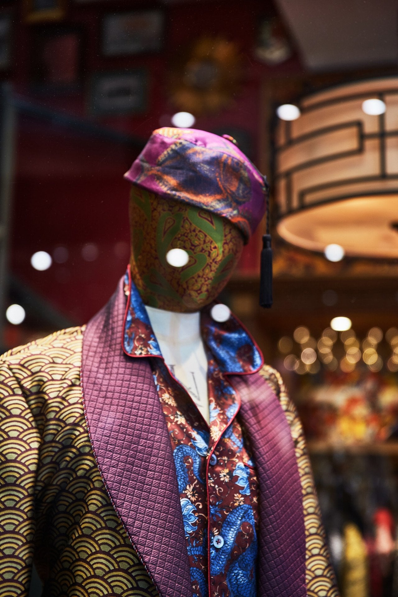 Silk dress coat and hat on mannequin in shop window in Picadilly Arcade, London