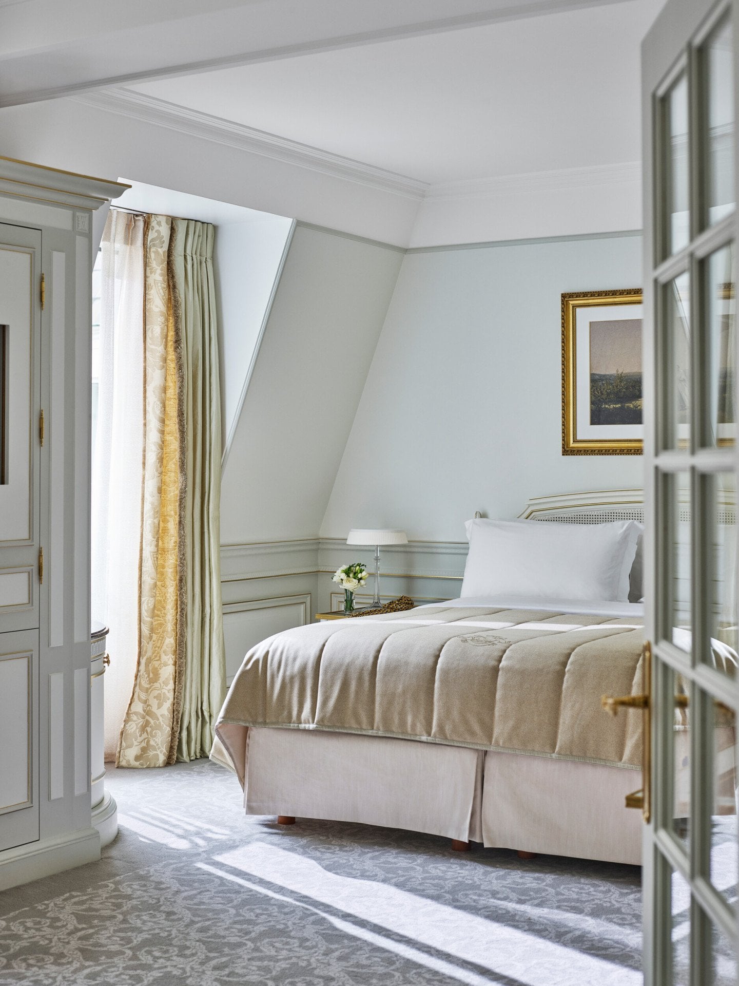 Quarto de uma suite júnior em tons de verde claro e bege no Le Meurice, Paris.
