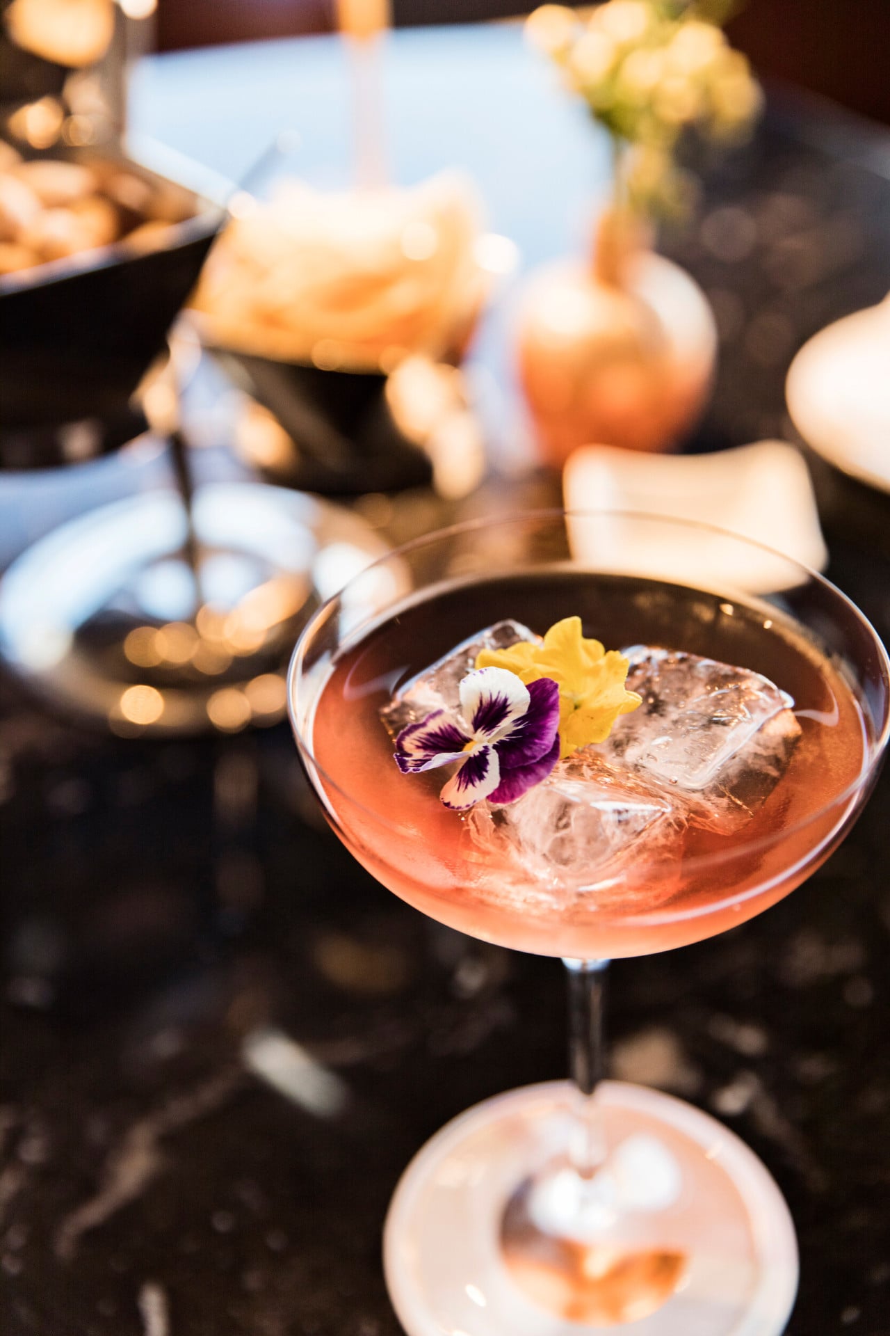 Coppa di cocktail La Grande Bellezza appoggiata su di un tavolo a Il Giardino bar