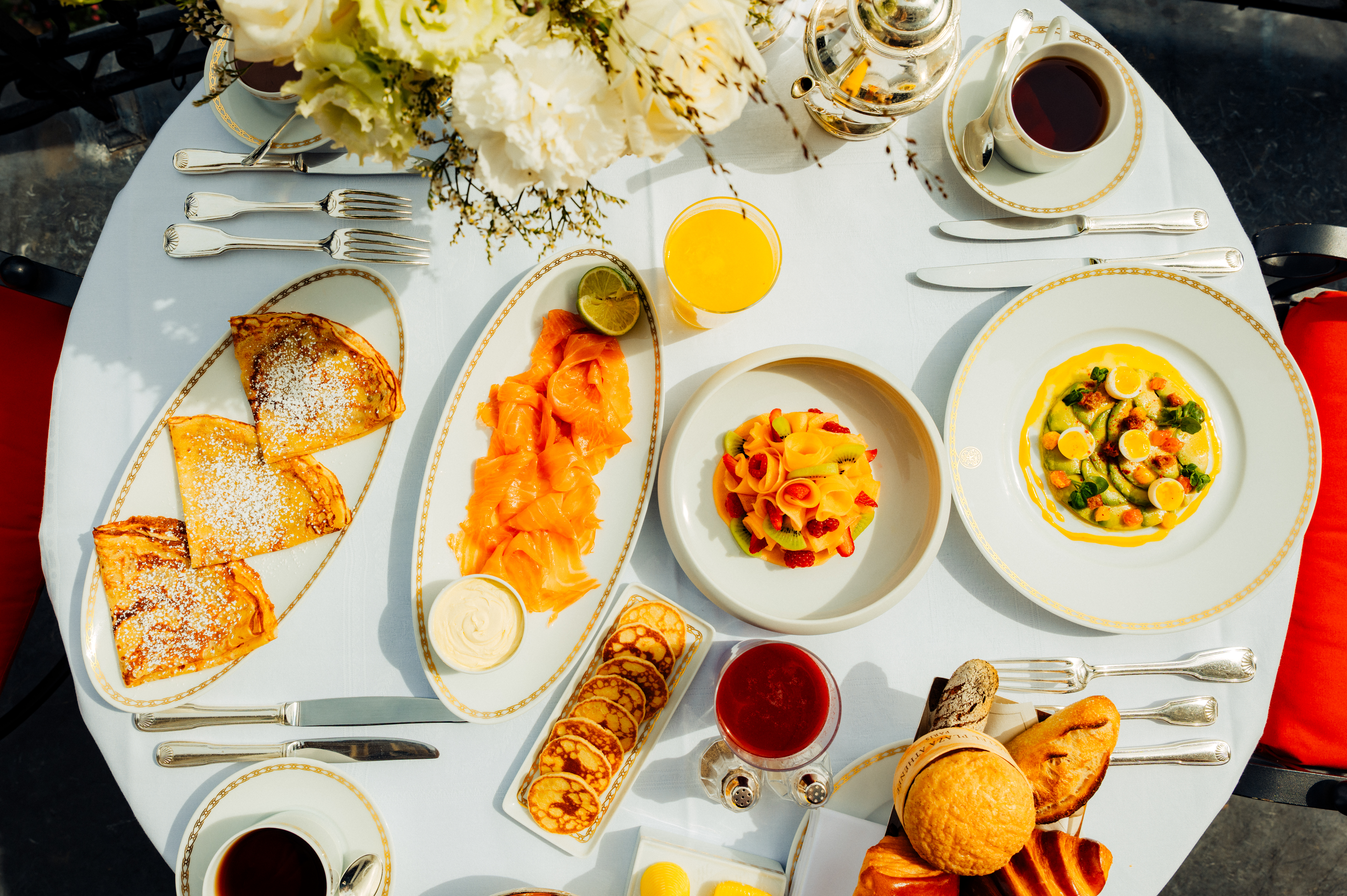 Breakfast, savoury and sweet treats on a white table at Plaza Athénée