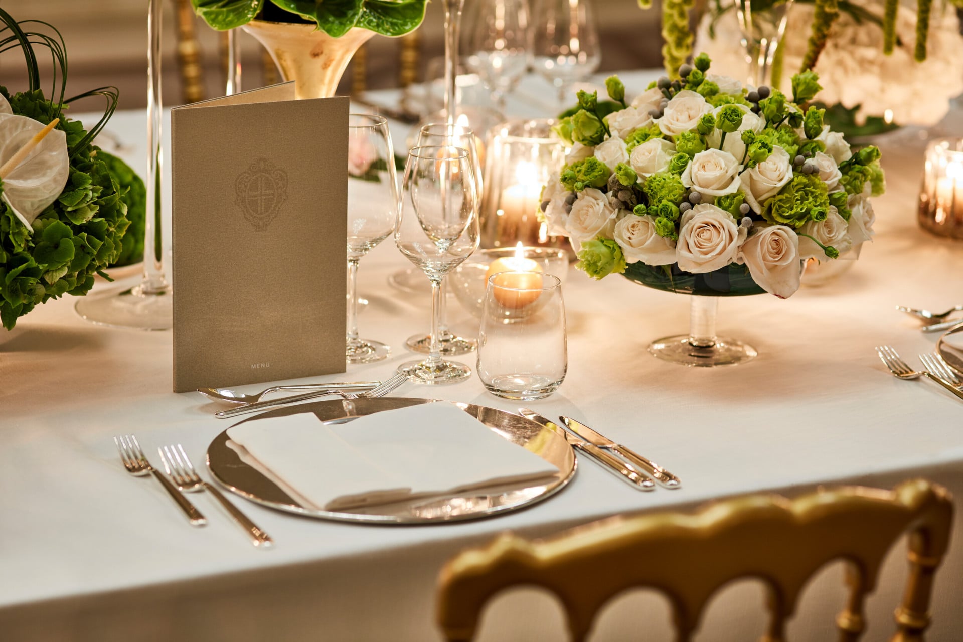 Detail of a wedding table with white roses centrepiece and exclusive tableware