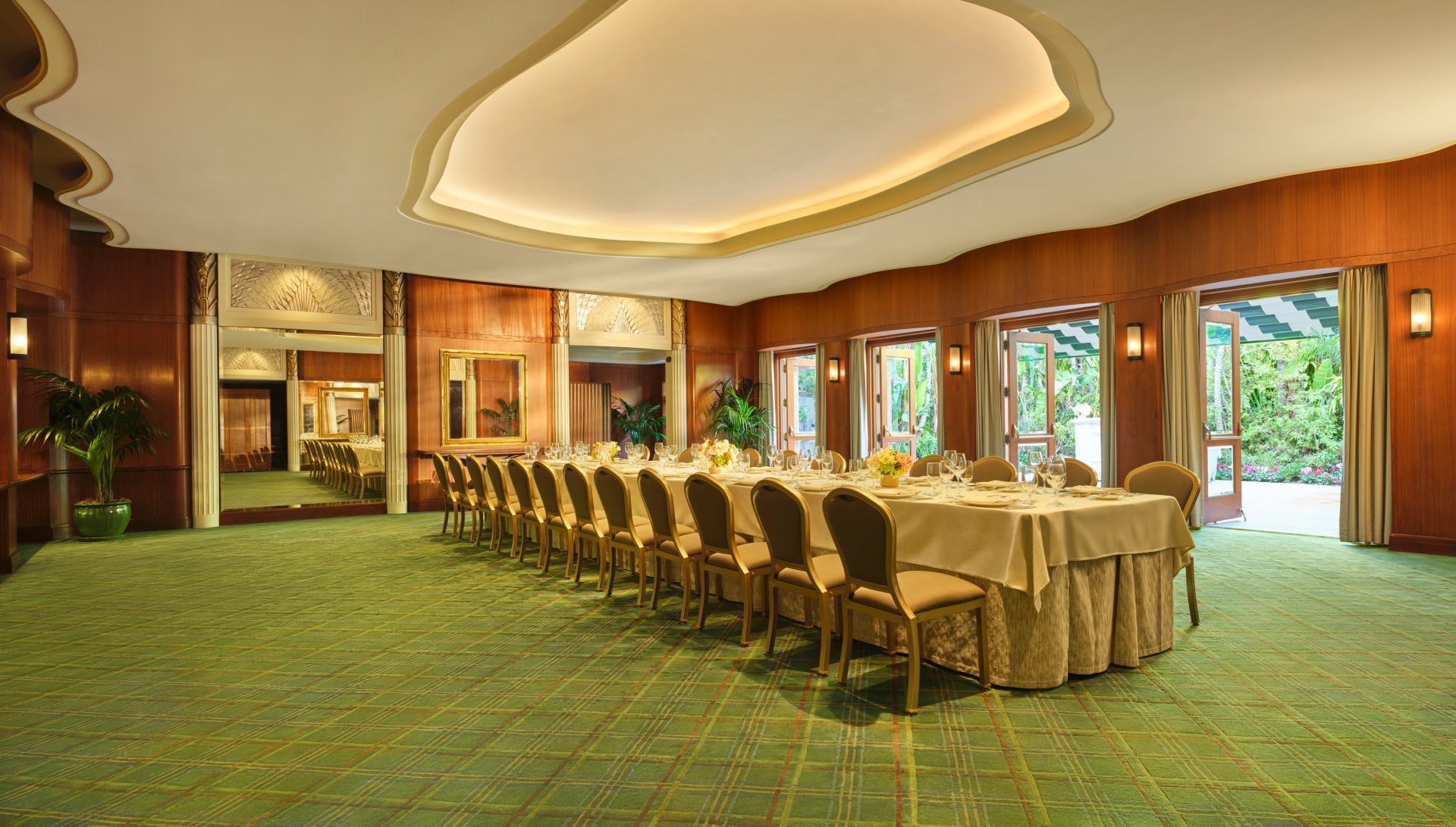 Empty banquet room with a long table set for a meal in a bright, elegant setting