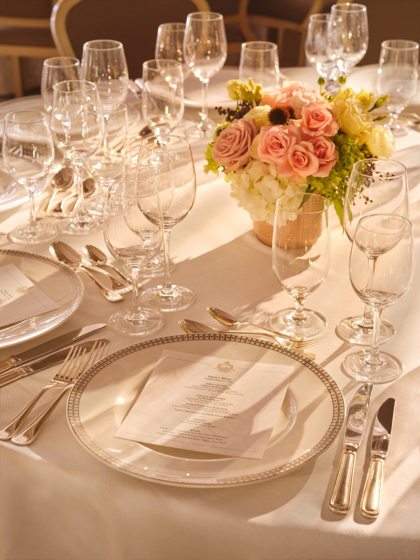 Elegant table set with floral centerpiece and multiple glasses, ready for a formal meal.