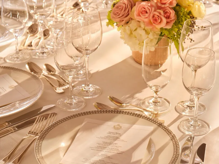 Elegant table set with floral centerpiece and multiple glasses, ready for a formal meal.