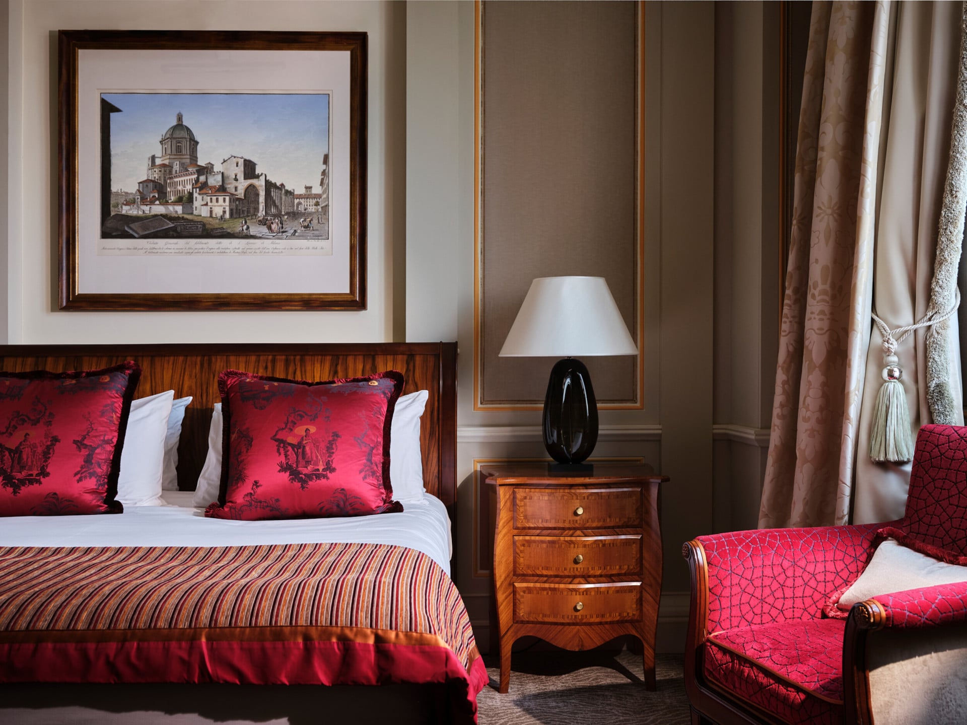 Camera classica con letto e poltrona con dettagli rossi