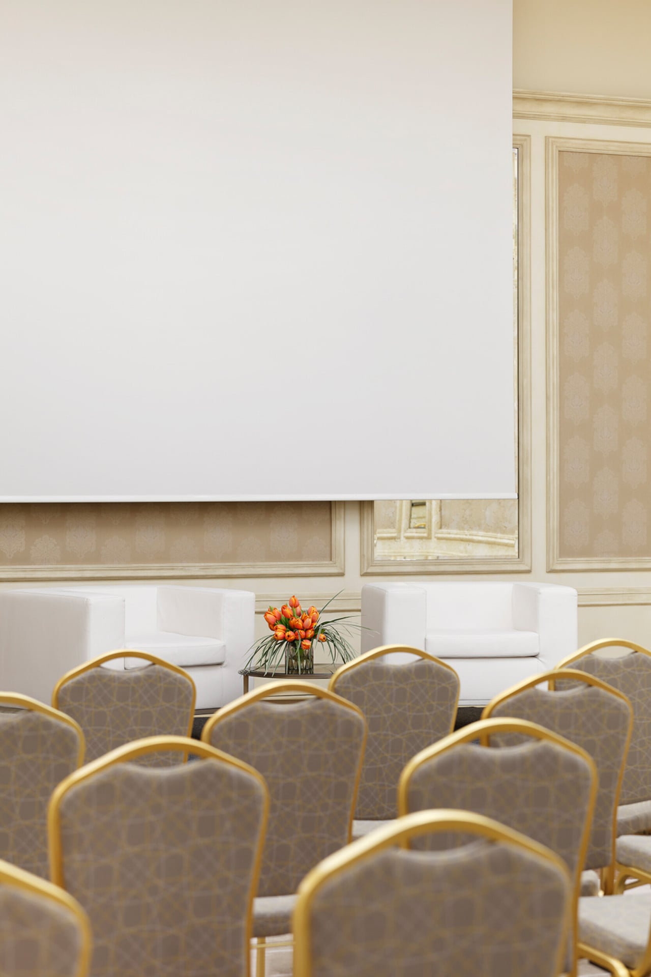 'Cartesio' meeting room with theatre set up. A bunch of orange tulips on the table between the two seats reserved for the speakers at the meeting in the background.