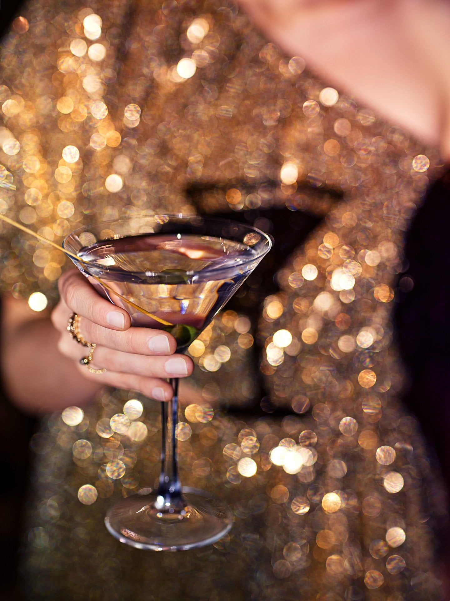 Women in a golden sequi dress holding a martini glass in her hand in the Salon Tuileries at Le Meurice, Paris - Dorchester Collection