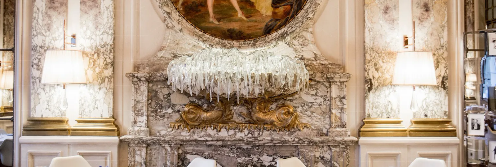 Photo panoramique de deux tables mettant en avant la sculpture murale en verre du restaurant Le Meurice Alain Ducasse, à l'hôtel Le Meurice, à Paris.