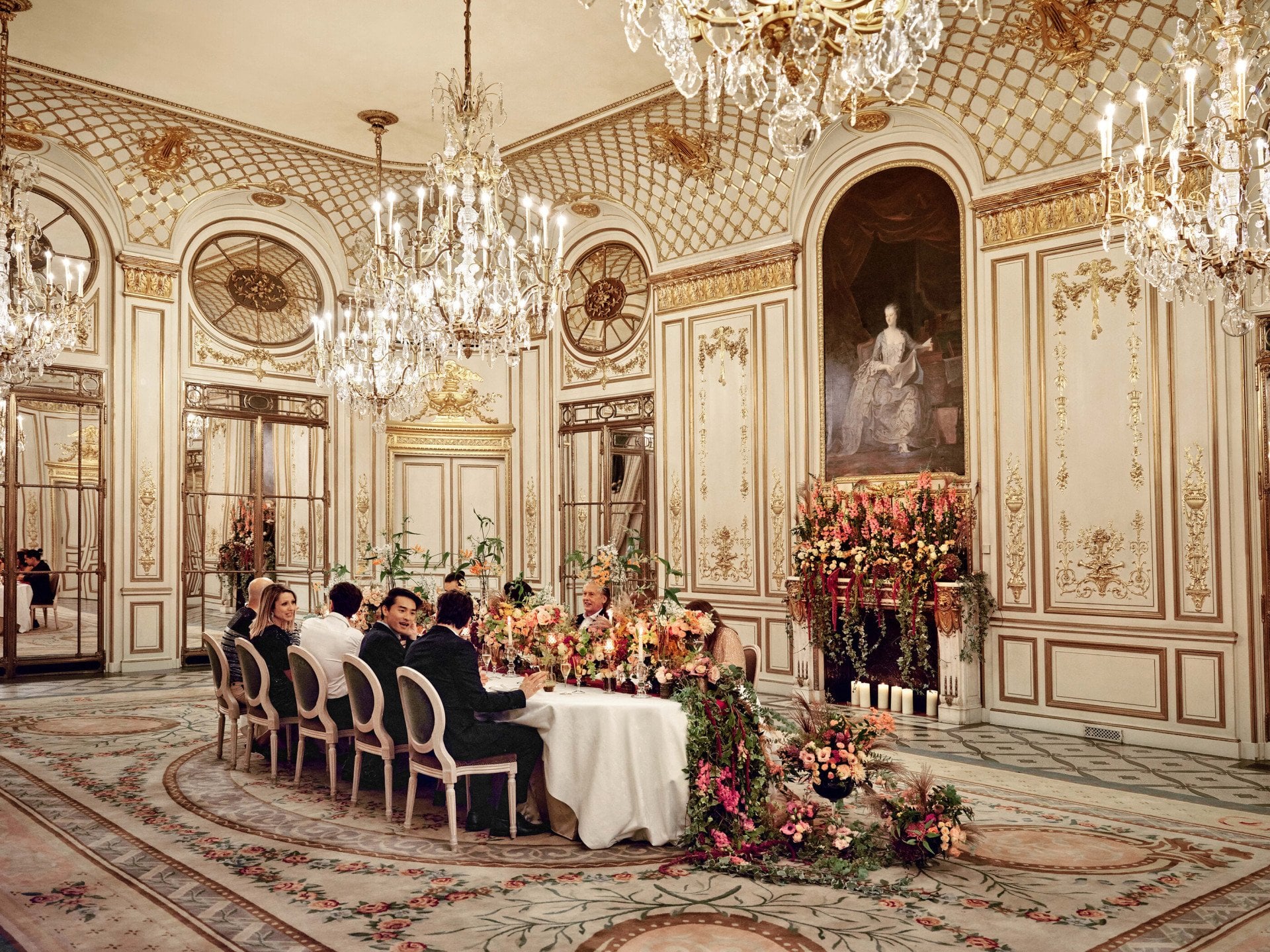Vue plan large d’un dîner au Salon Pompadour avec de personnes qui discutent à table au Meurice, Paris - Dorchester Collection