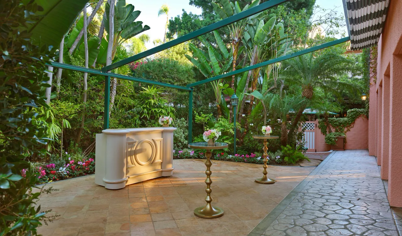 Garden decorated with candles and flowers on a sunny outdoor patio.
