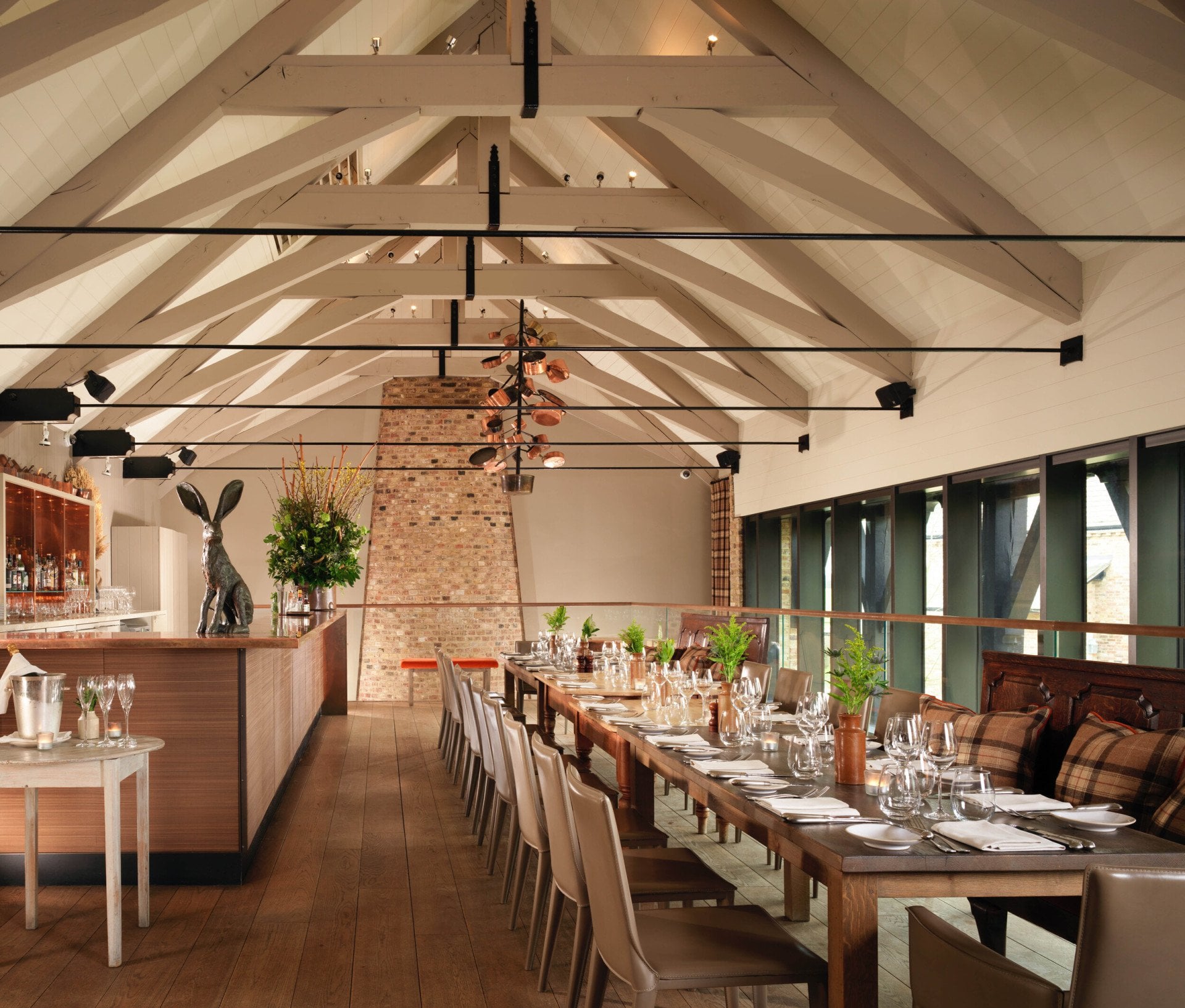 Mezzanine private dining room in The Barn with vaulted ceiling and exposed brick at Coworth Park