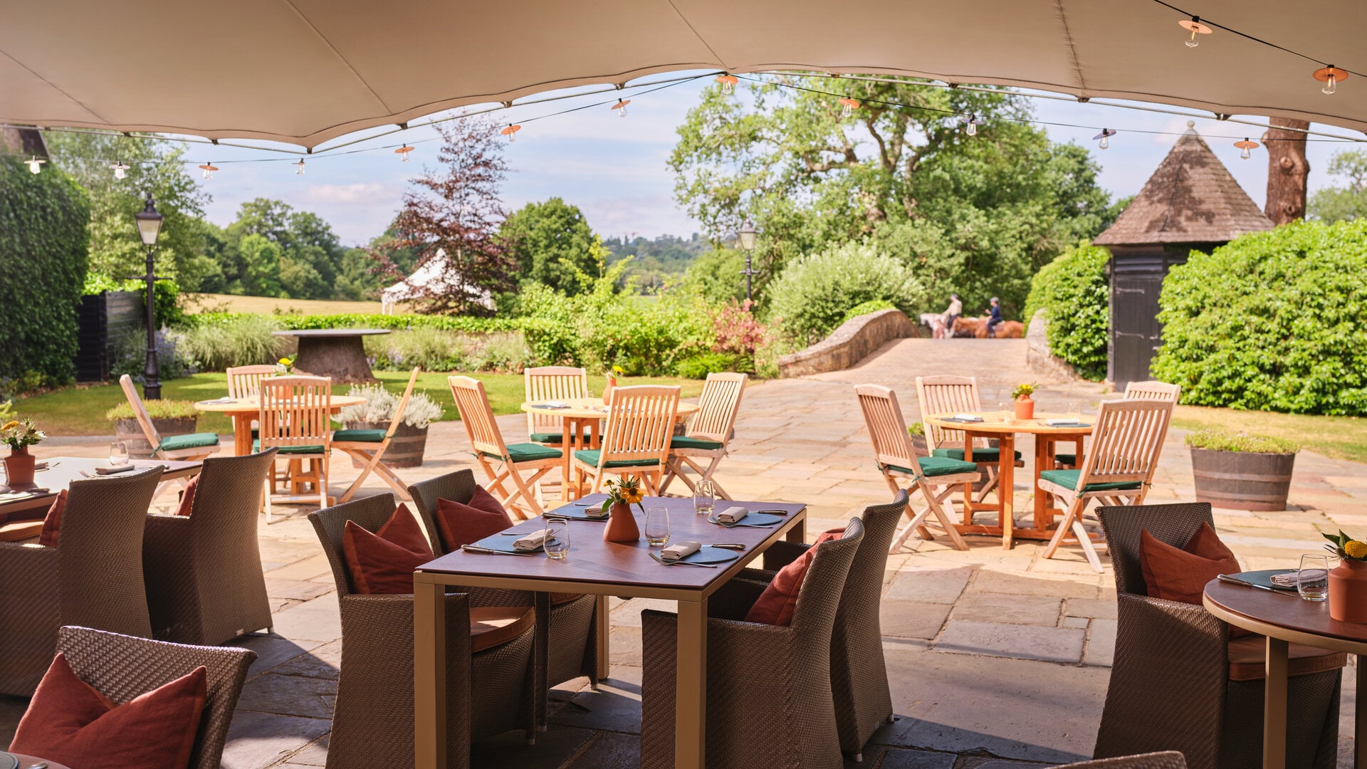 Al fresco dining terrace at The Barn at Coworth Park overlooking the gardens