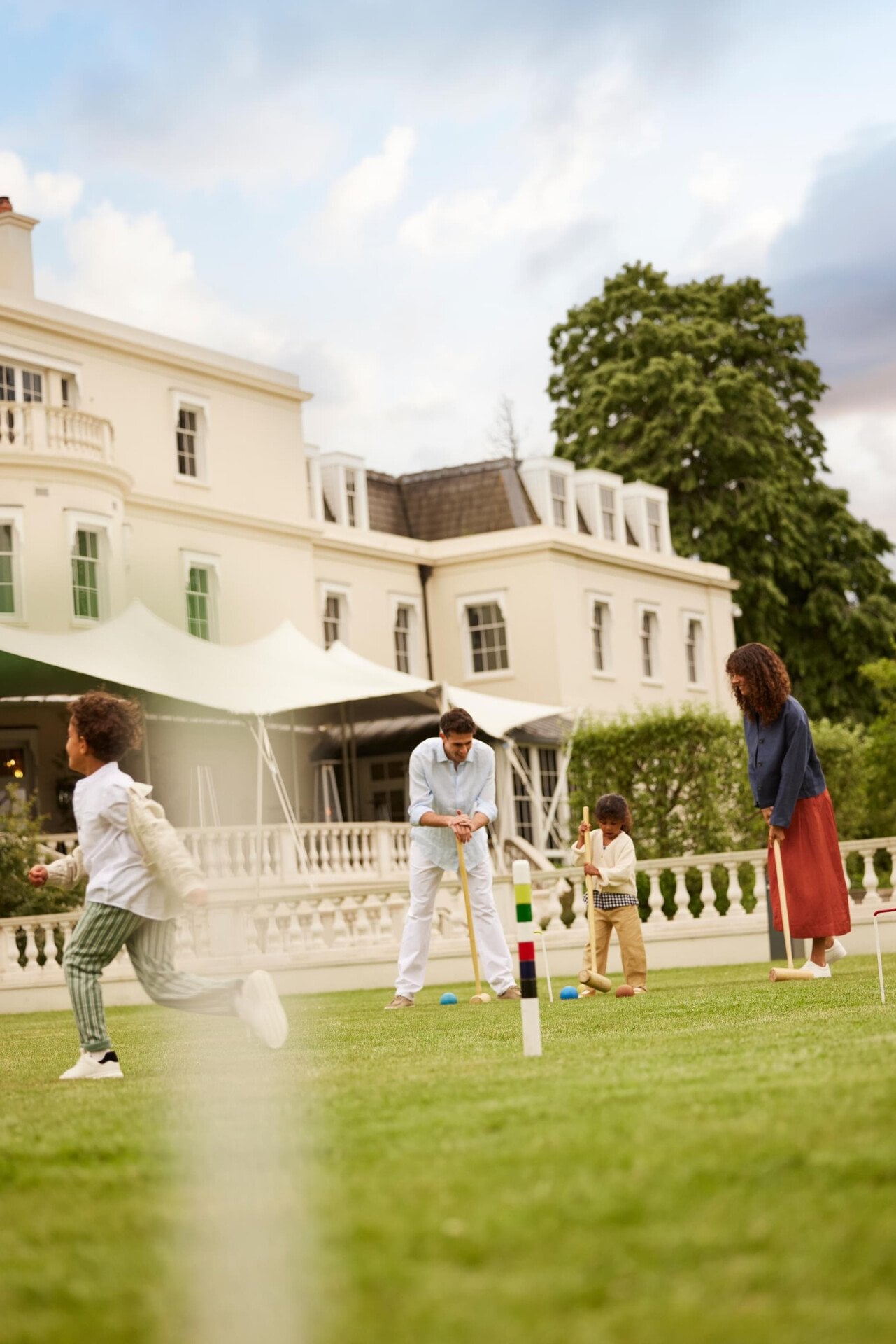 family playing Croquet at Coworth Park in the evening light