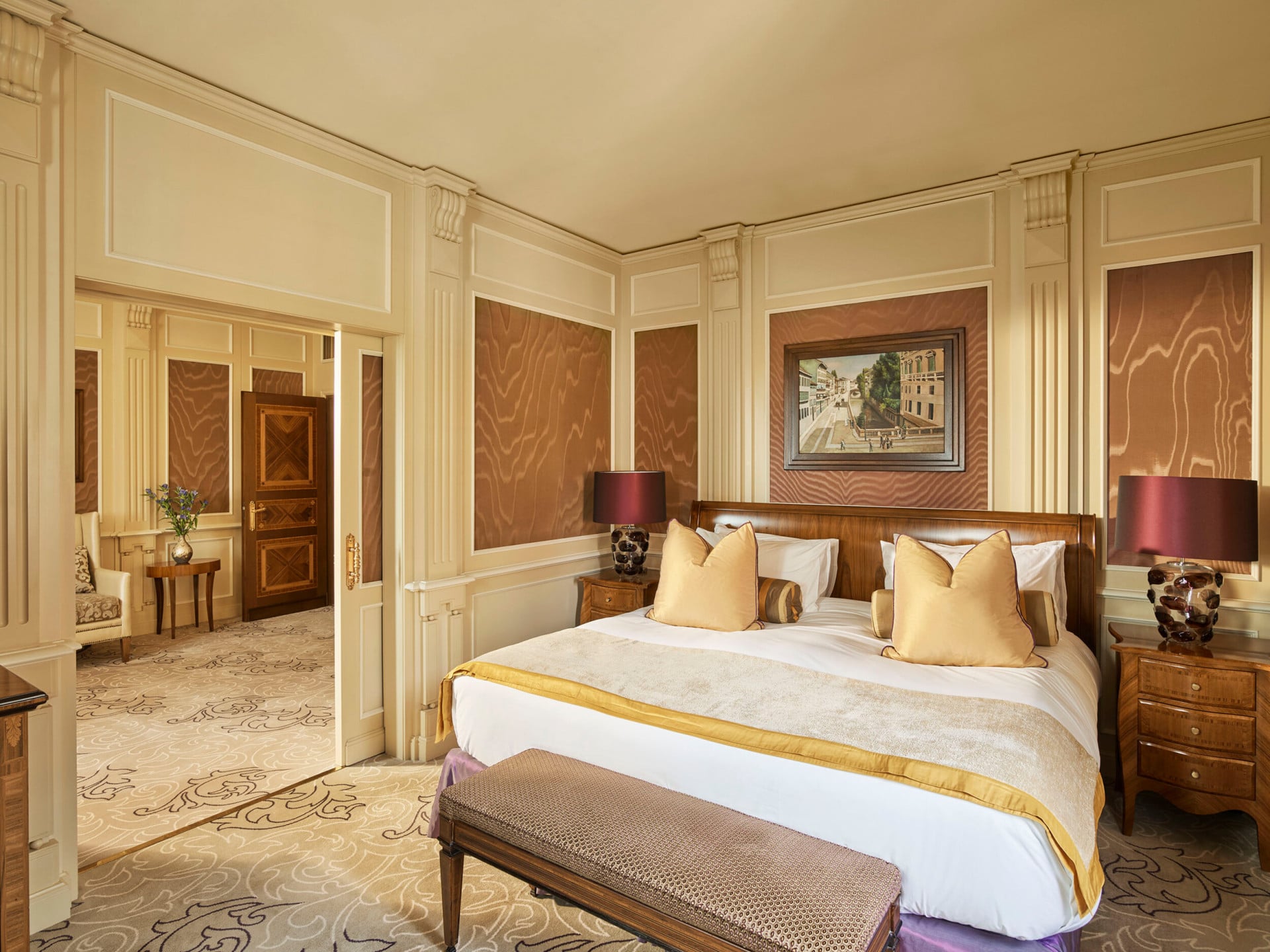 Ambassador Suite Bedroom decorated with warm colors but also touches of yellow and purple color