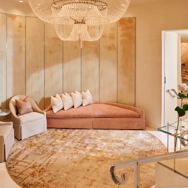 An inviting room with a chaise and a chandelier