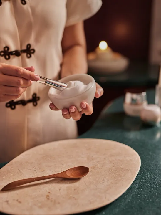 spa attendant preparing massage supplies
